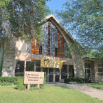 front of church with standing on the side of love banner