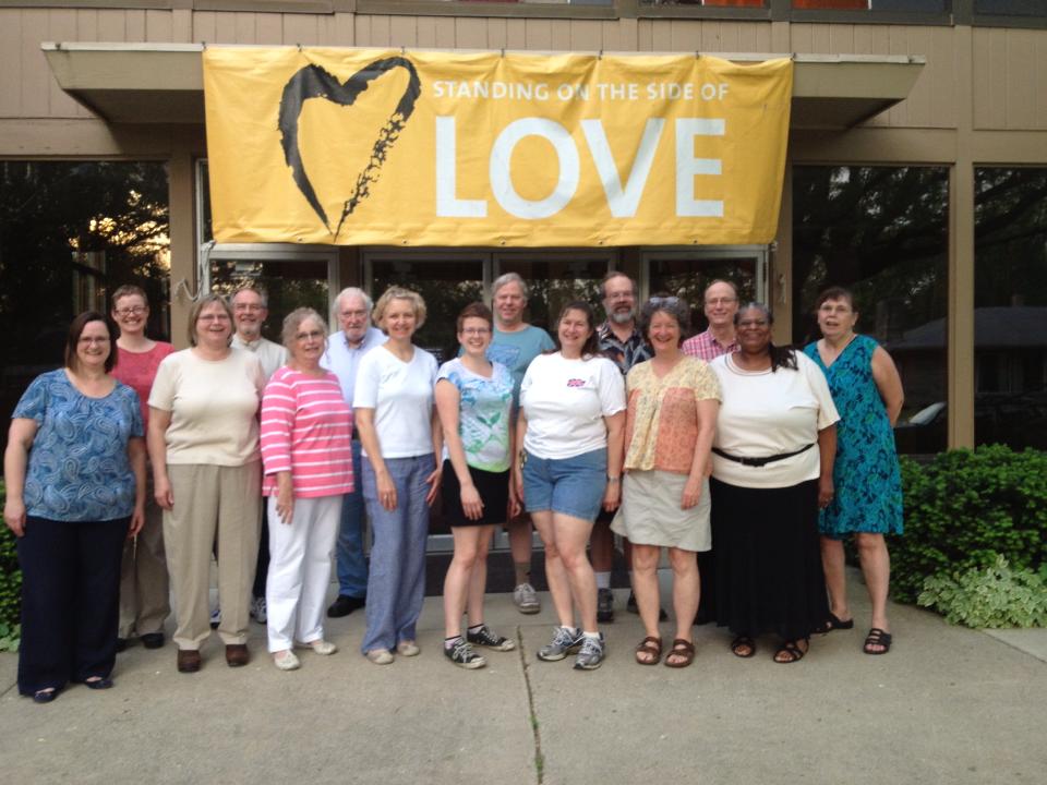 Church members in front of Standing on the side of love banner